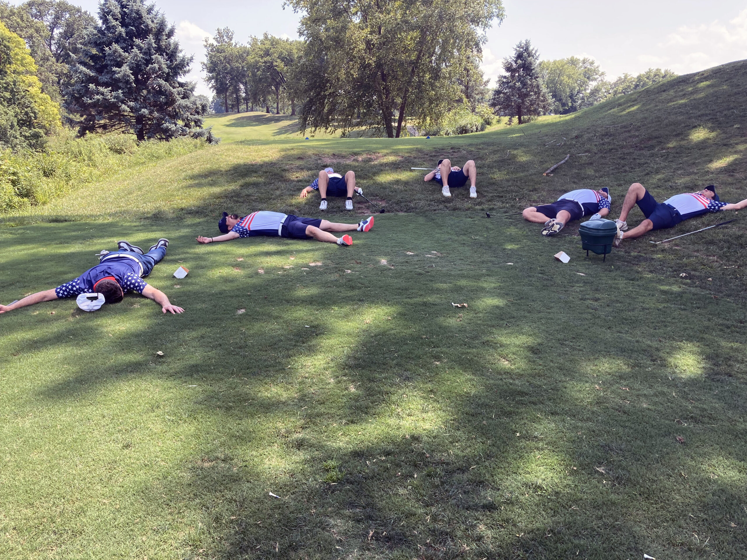 100 Holes Golfers laying on the ground in exhaustion